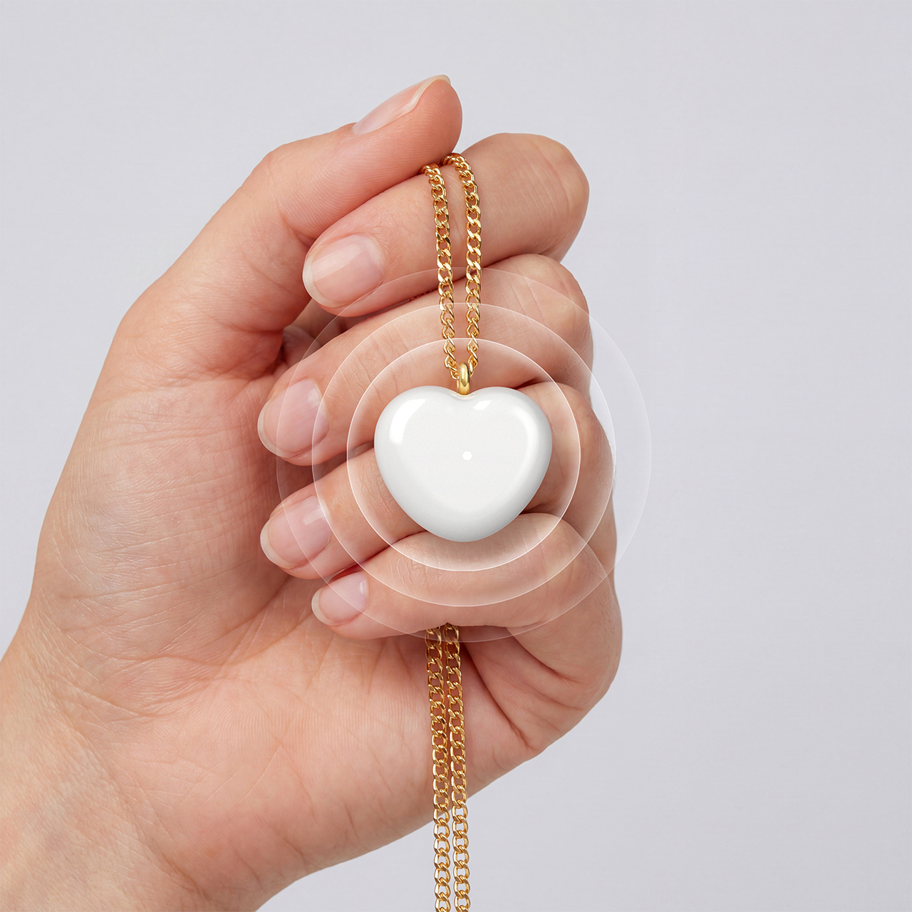 A hand holding the Bond Heart pendant