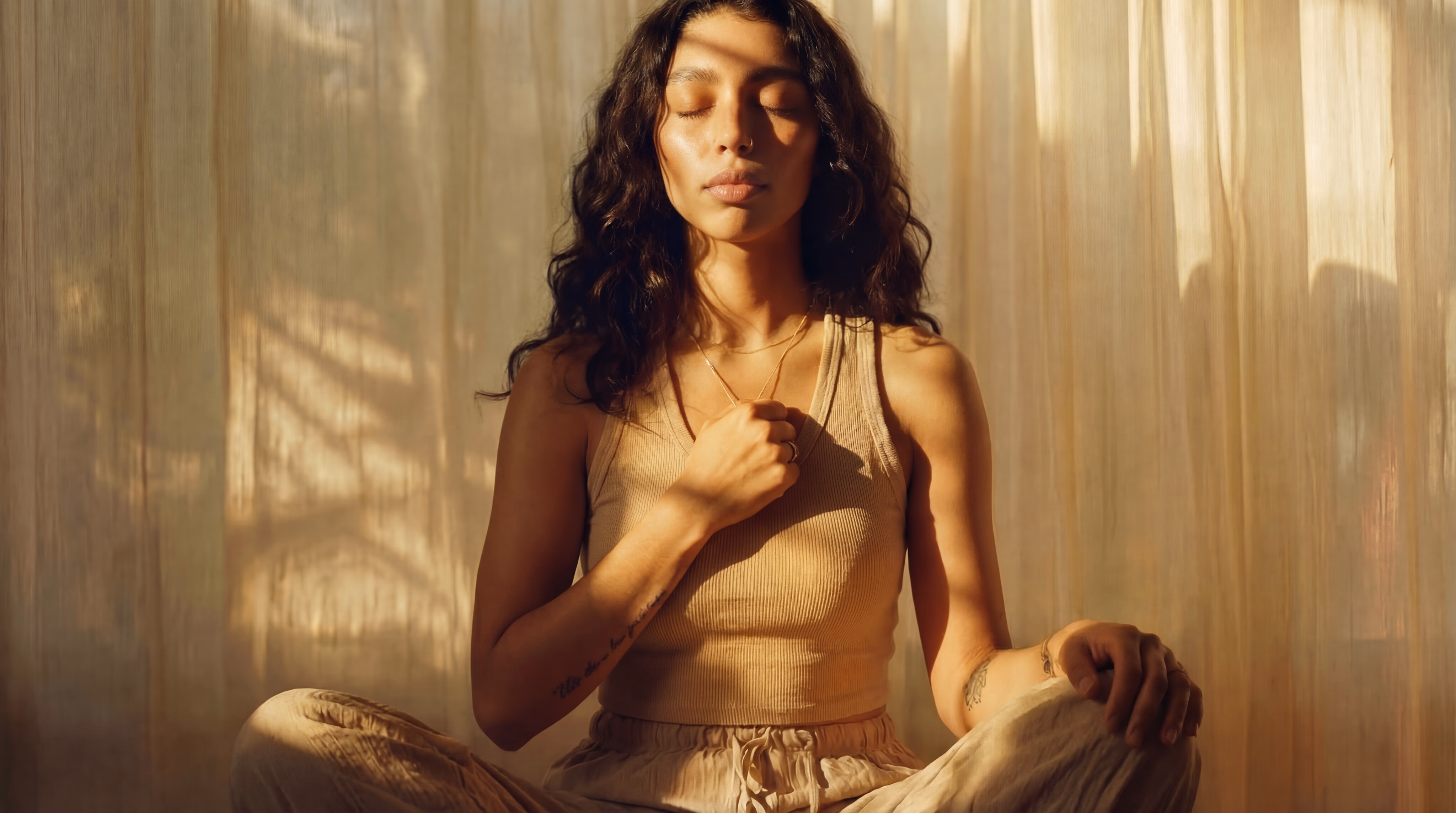 A woman sitting in stillness, holding the Bond Heart pendant